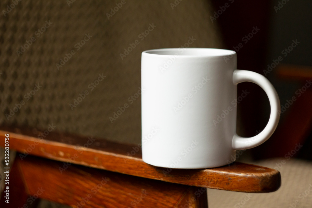 White mug on the armrest of a chair