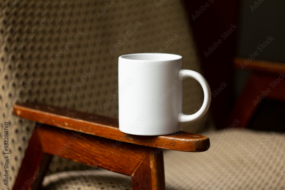 White mug on the armrest of a chair