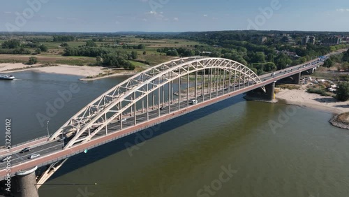 The Waalbrug is an arch bridge over the Waal that connects the center of Nijmegen with Lent. Roads N325 and S100 city route infrastructure. Connection part of city skyline. Aerial drone view. photo