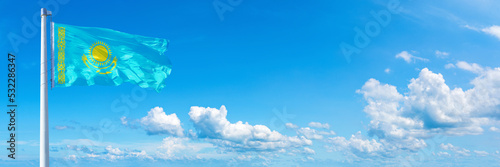 Kazakhstan flag on a blue sky *** Horizontal banner 12000 x 4005 px