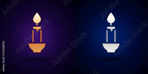 Gold and silver Burning candle icon isolated on black background. Cylindrical candle stick with burning flame. Vector