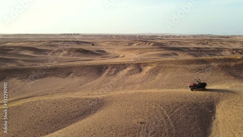 A buggy vehicle moving on sandy terrains on a sunny day. photo