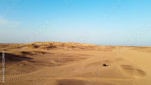 A high aerial shot of the Egyptian desert with a buggy car moving. photo