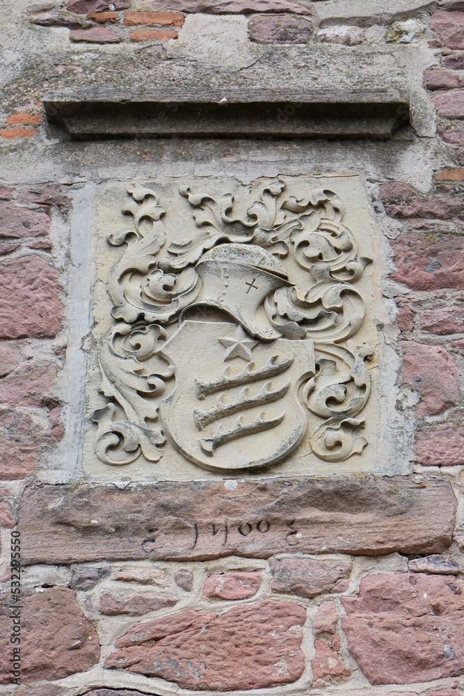 Riquewihr, France. Carved stone marker from the 1400s on the clock tower.