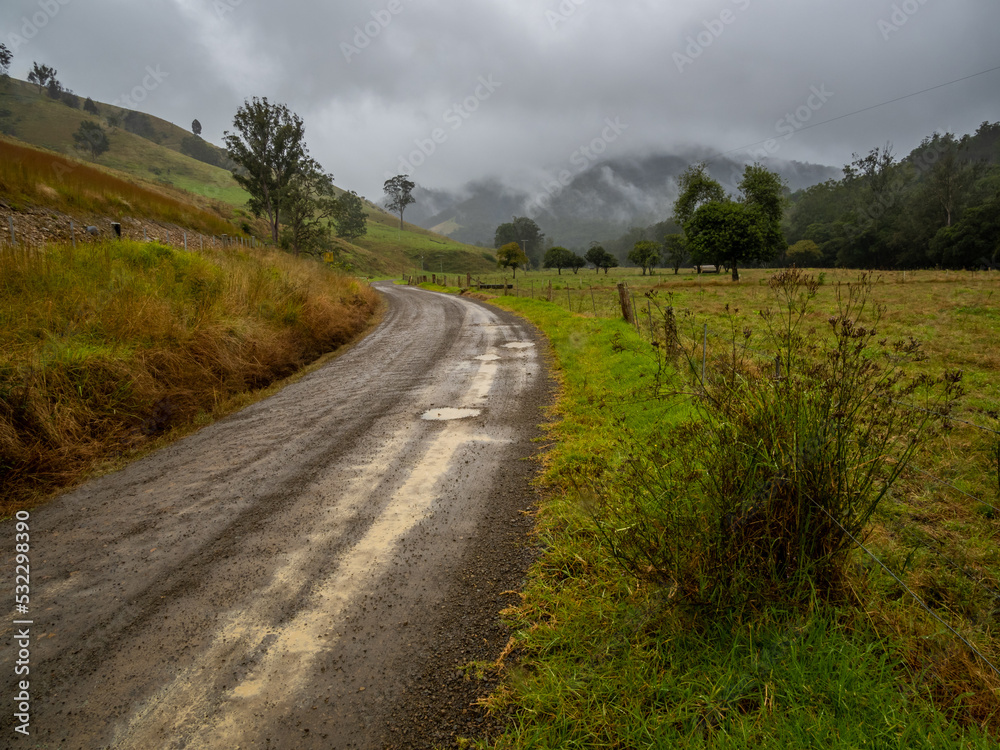 Dirt Road through Rural Scene with Wet Weather