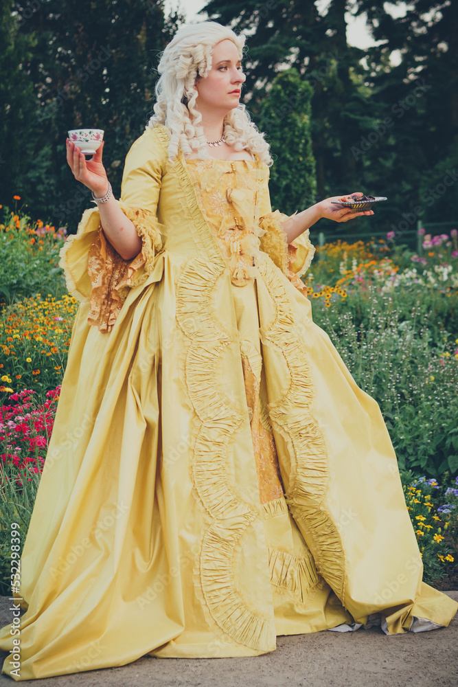 Portrait of blonde woman dressed in historical Baroque clothes with old  fashion hairstyle, outdoors. Golden color dress. Luxurious medieval dress  Stock Photo