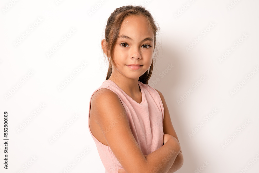 Smiling little brunette girl posing with arms folded isolated over white background. Smiling little brunette girl posing with arms folded isolated over white background.