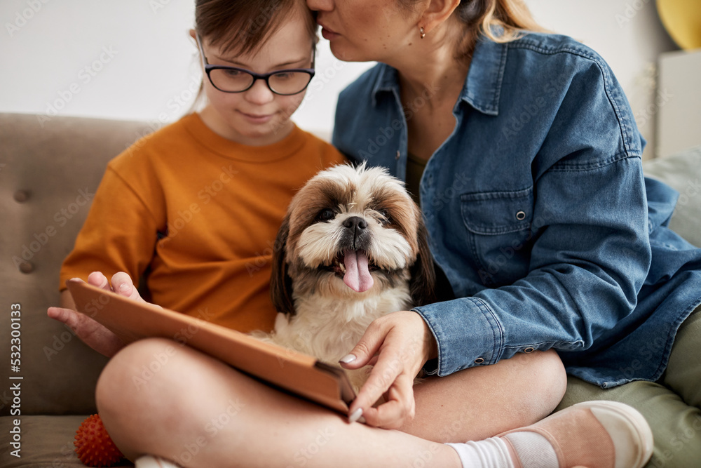 Portrait of small cute dog sitting on couch with family and looking at camera, copy space Portrait of small cute dog sitting on couch with family and looking at camera, copy space