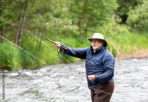 An older man tries his luck at fly fishing for salmon. Russian River. Cooper Landing, Alaska.
