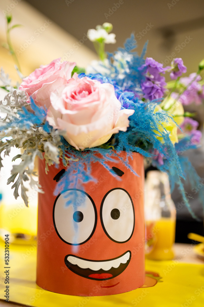 Fototapeta premium bouquet of pink flowers with a vase with a painted face