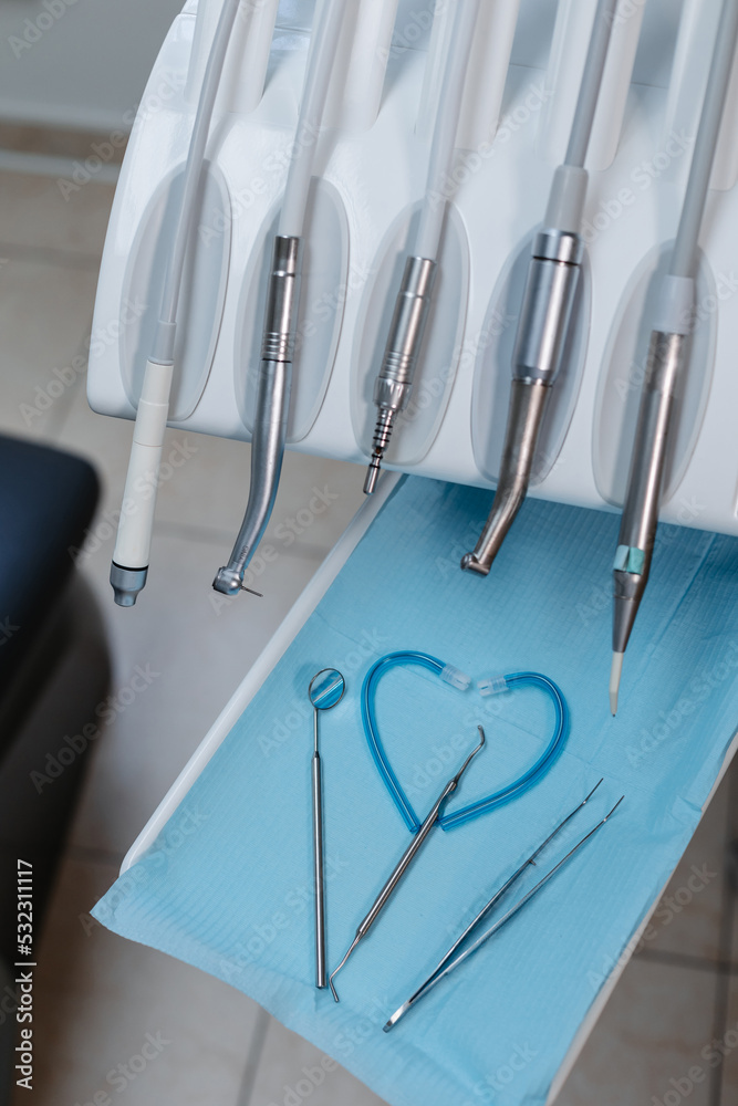 An injection for anesthesia of the tooth and a set of tools of the dental chair, close-up. Heart made of dentist's tools.