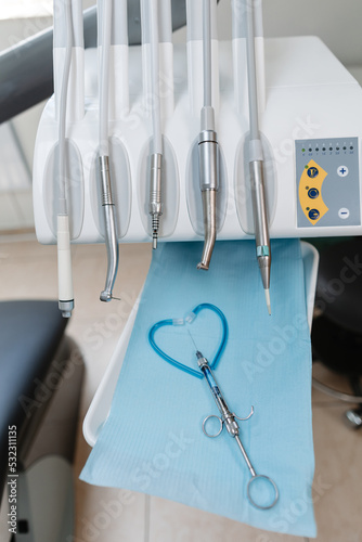 An injection for anesthesia of the tooth and a set of tools of the dental chair, close-up. Heart made of dentist's tools.
