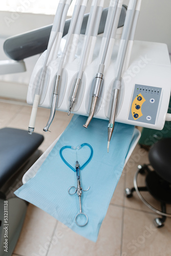 An injection for anesthesia of the tooth and a set of tools of the dental chair, close-up. Heart made of dentist's tools.