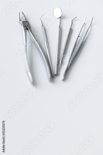 Metal tools of the dentist on a white background. Aesthetics of dentistry. forceps  tweezers  mirror  curettes and scalers