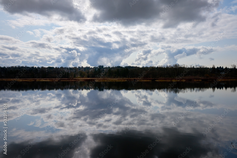 Storm Cloud Break Water Reflection. Cloud reflections on Burbaby Lake, British Columbia, Canada.


