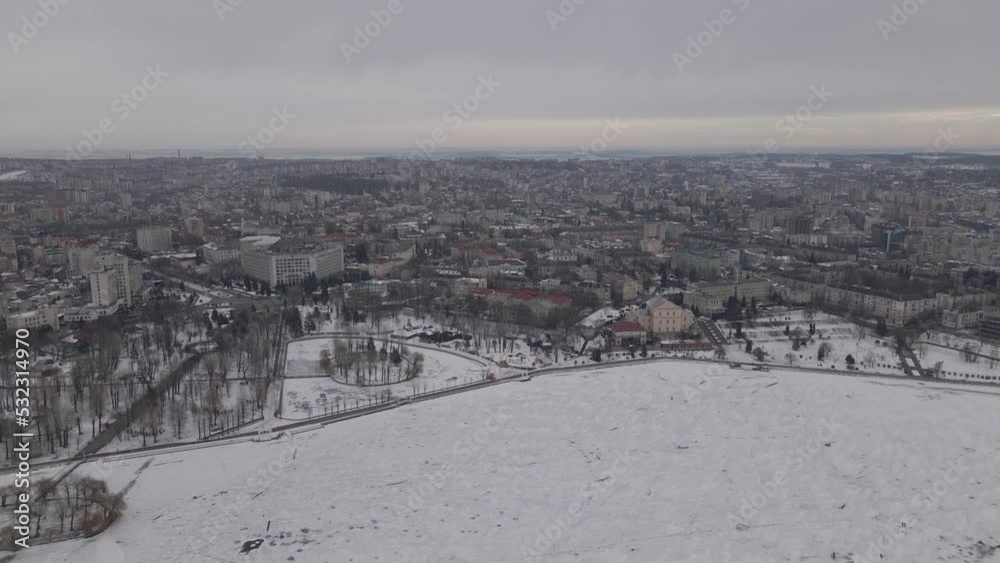 Aerial panoramic view on a small town Ternopil with frozen city pond at winter, drone is flying forwards Aerial panoramic view on a small town Ternopil with frozen city pond at winter, drone is flying forwards