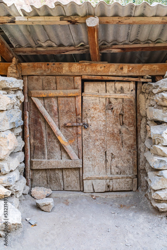 Haft Kul, Sughd Province, Tajikistan. Old wooden doors in a stone building.