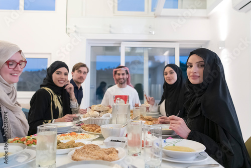 Eid Mubarak Muslim family having Iftar dinner drinking water to break feast. Eating traditional food during Ramadan feasting month at home. The Islamic Halal Eating and Drinking at modern western Isla photo