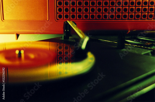 Close up of a vinyl record in a retro turntable and red cabinet behind photo