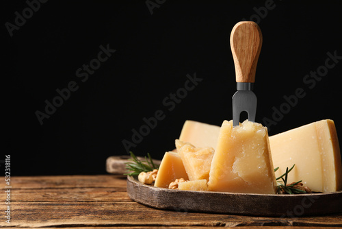 Delicious parmesan cheese with rosemary on wooden table. Space for text
