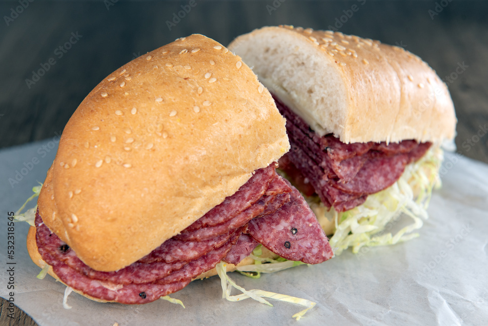 Lunch is served with a loaded salami sandwich overflowing with romaine lettuce Stock Photo