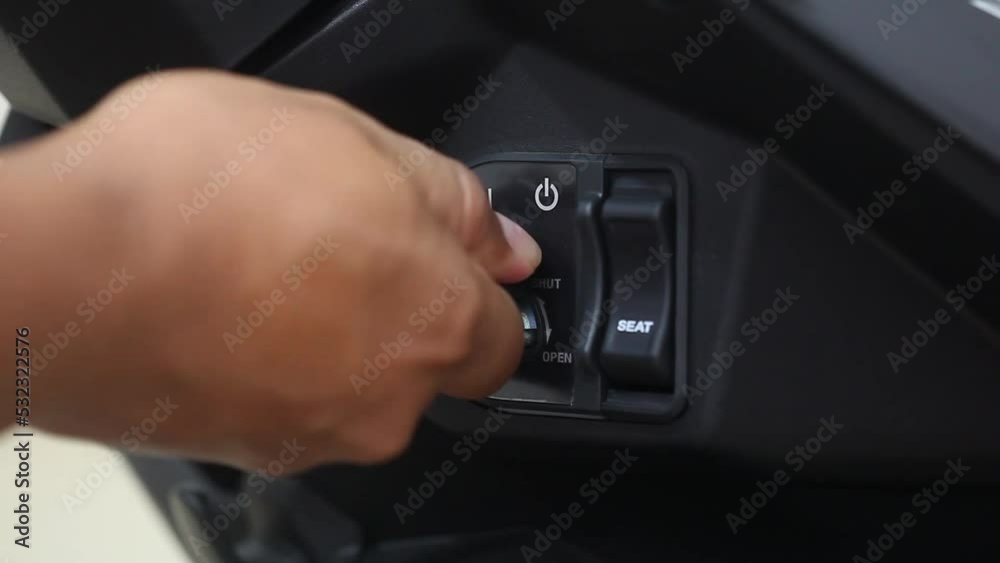 Man hand inserting key for starting motorcycle engine. Close up moto biker starting motorcycle for driving
