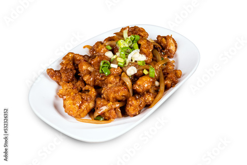 Chinese and oriental dish Chili Chicken garnished with green onions on a white plate isolated on white