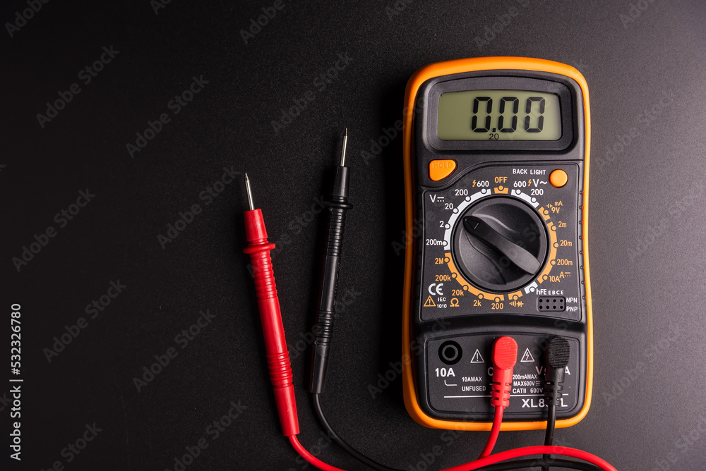 Yellow Digital multimeter with probes on black background , A multimeter is an electronic measuring instrument. Yellow Digital multimeter with probes on black background , A multimeter is an electronic measuring instrument.