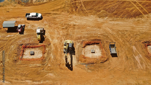 overhead view of excavator, bulldozer, and truck on grading job site