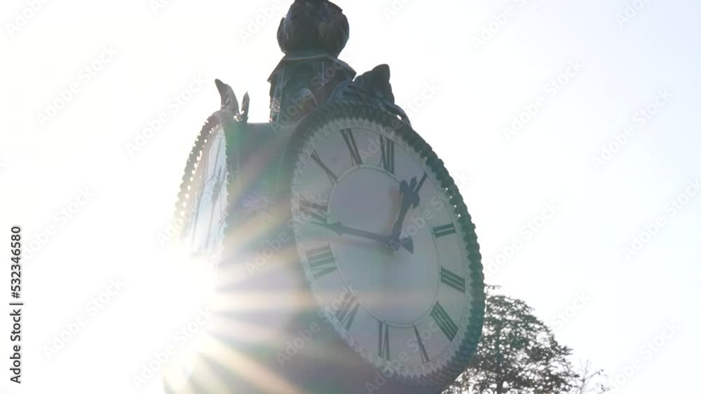 Antique street clock. Sunbeams, early morning, dawn. Closeup,