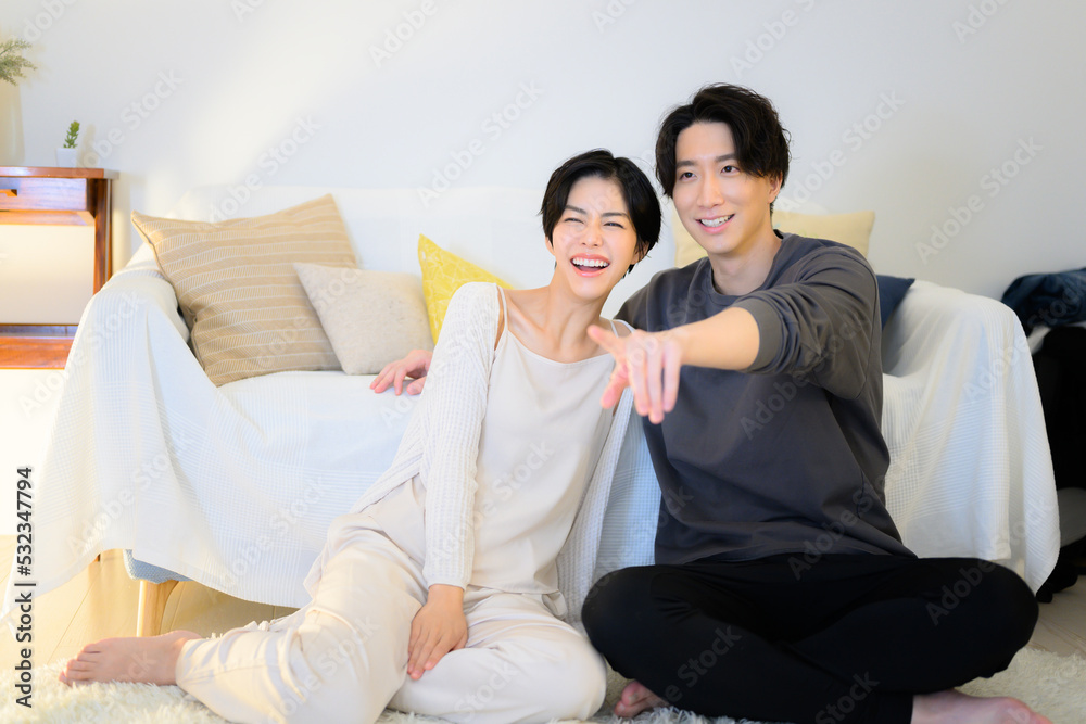 夜に動画やテレビなどを見てくつろぐカップル 広角 夜に動画やテレビなどを見てくつろぐカップル 広角