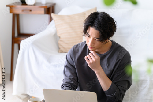 パソコンをするハンサムな男性 　考える　前ボケあり