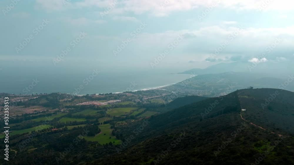 Aerial orbit of mountains and a village on a cloudy day that barely lets the sun's rays through. Aerial orbit of mountains and a village on a cloudy day that barely lets the sun's rays through.