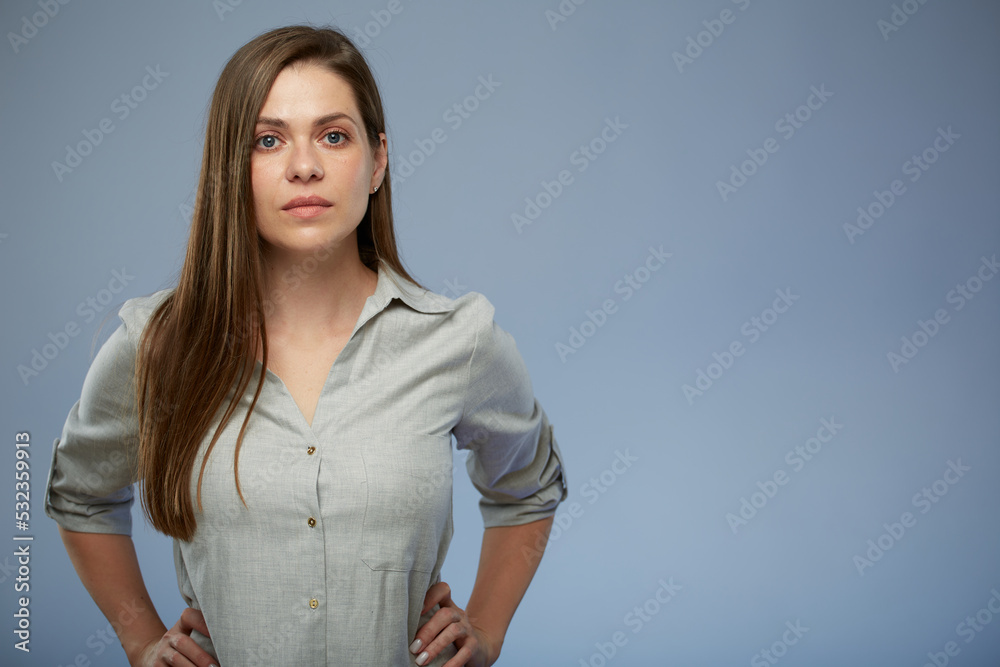 Serious woman in gray shirt. Isolated female portrait on blue background Serious woman in gray shirt. Isolated female portrait on blue background