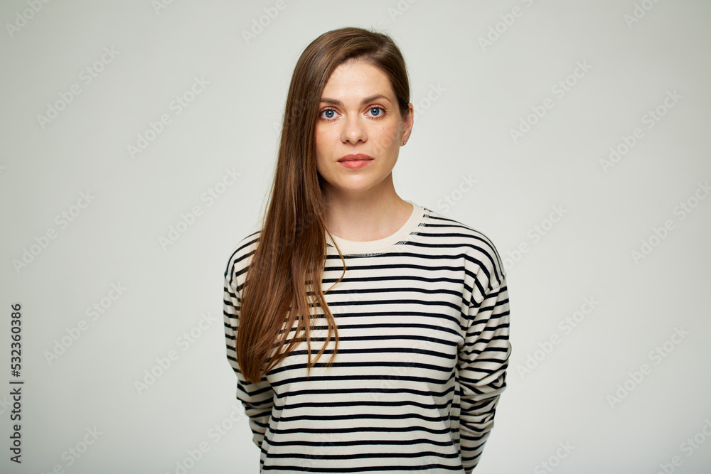 Serious woman in casual clothes holding hands back. Isolated female portrait. Serious woman in casual clothes holding hands back. Isolated female portrait.
