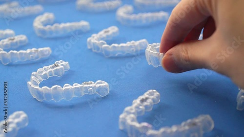Line up multiple orthodontic clear aligners for teeth. slow motion video.