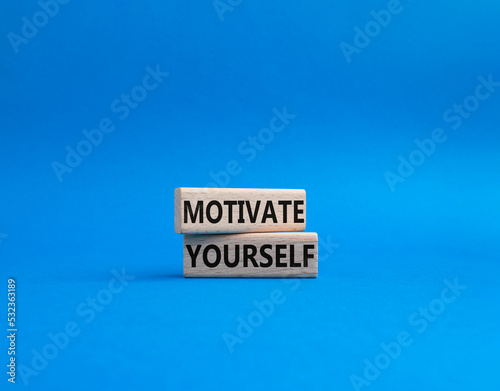 Motivation symbol. Concept words 'Motivate yourself' on wooden blocks. Beautiful blue background. Business and Motivate yourself concept. Copy space.