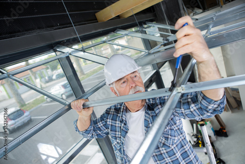 contractor erecting framework for suspended ceiling
