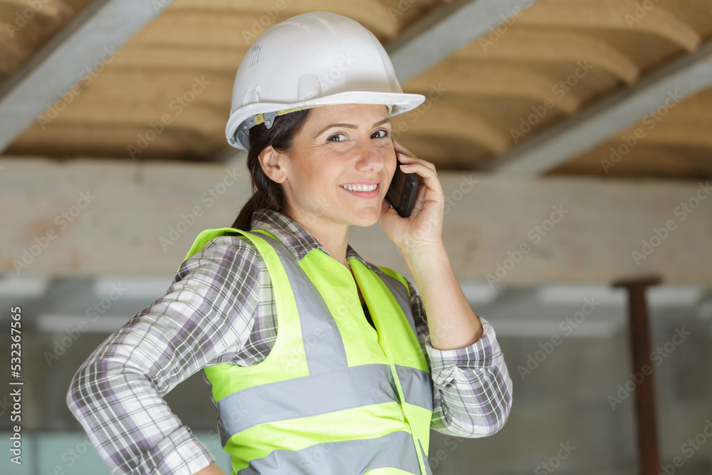 smiling female builder talking on the mobile phone smiling female builder talking on the mobile phone