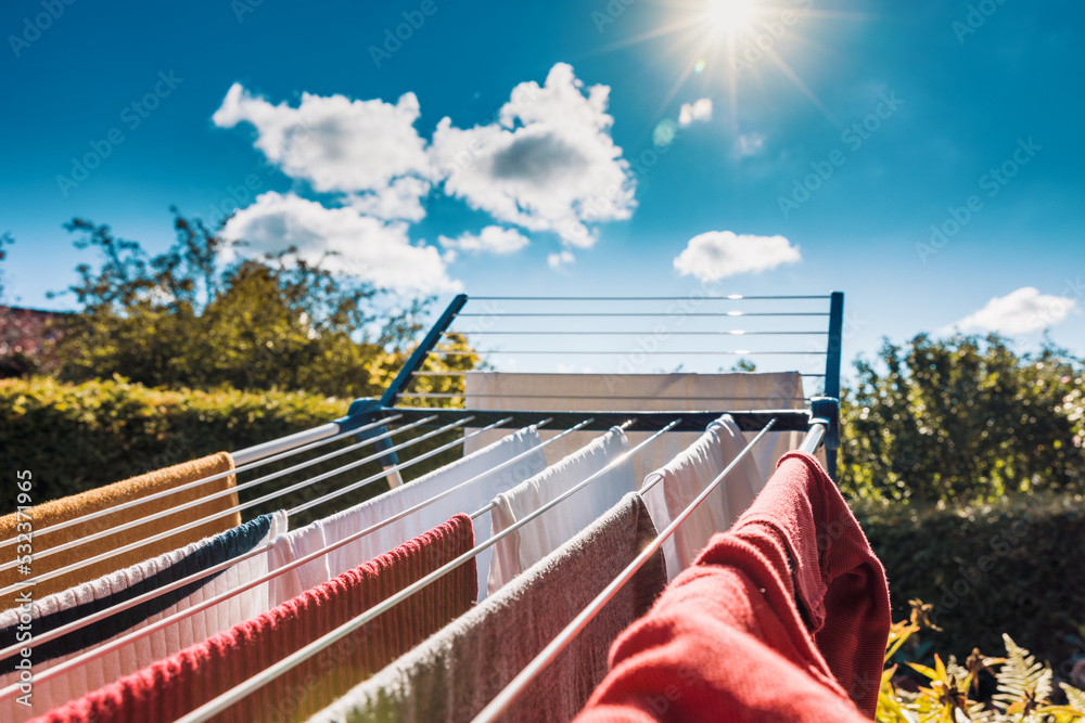 Drying wet clothes ecofriendly in the sun on a drying rack during