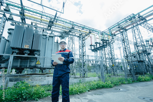 An energy engineer inspects the modern equipment of an electrical substation before commissioning. Energy and industry. Scheduled repair of electrical equipment.