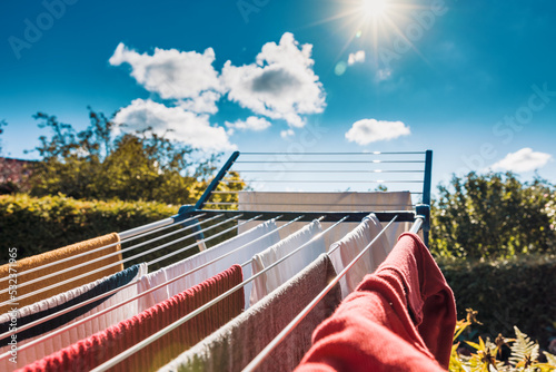 Φωτογραφία Drying wet clothes ecofriendly in the sun on a drying rack during summer after l