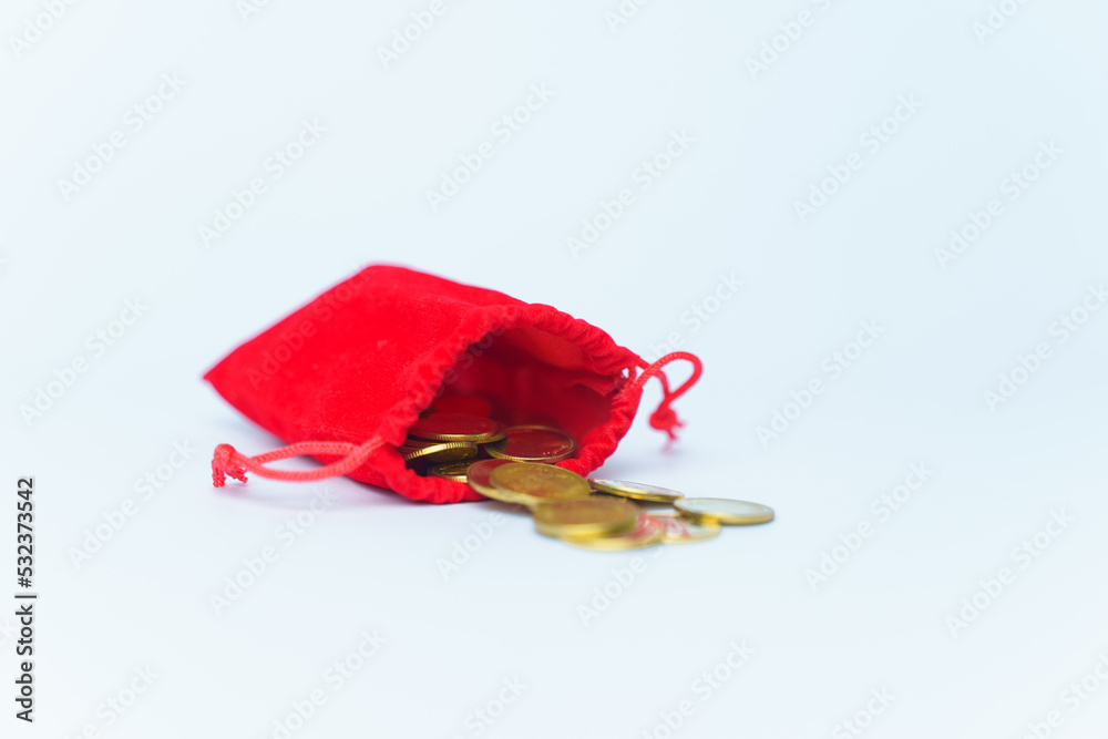 A bag with gold coins on a white background. The money is in a red bag. A bag with gold coins on a white background. The money is in a red bag.