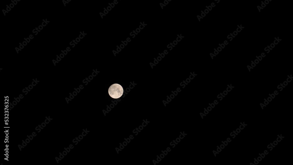 Wide timelapse of almost full moon moving fast across clear black sky Wide timelapse of almost full moon moving fast across clear black sky