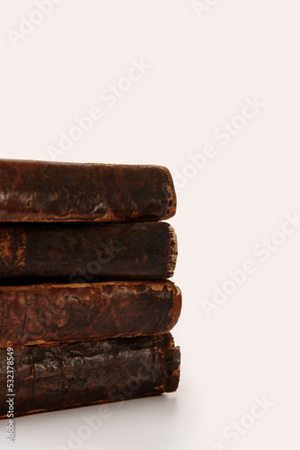 Obraz na płótnie Stack of old worn shabby Jewish books in leather binding on white background with reflection. Closeup. Selective focus. w salonie