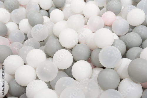 Pastel color white, grey, blue plastic balls background for baby activity. Kid's playing room interior. Copyspace