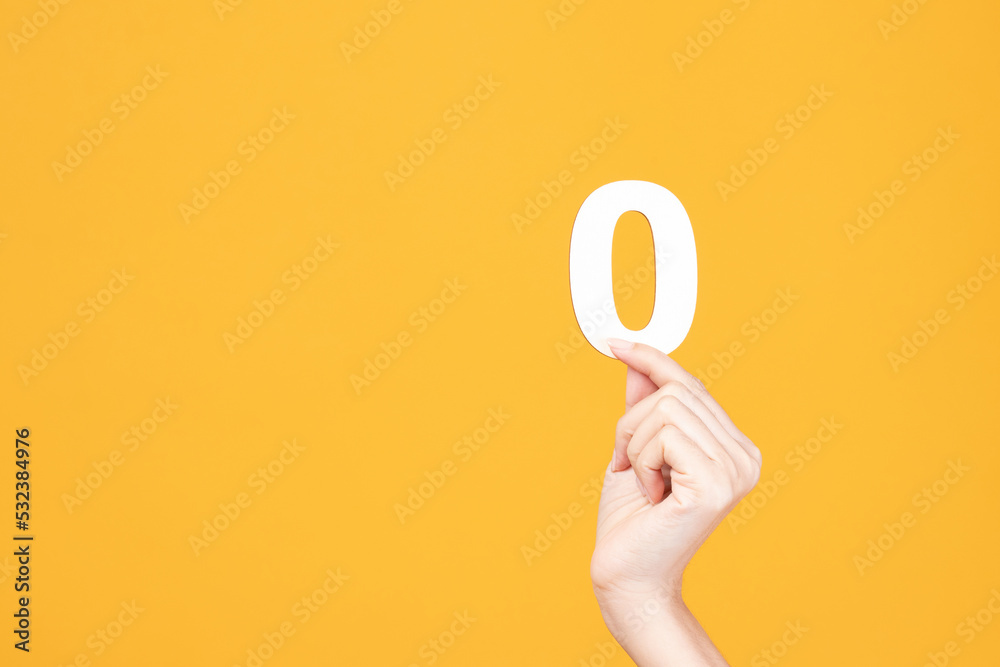 Hand holding wood number on yellow background. Hand holding wood number on yellow background.