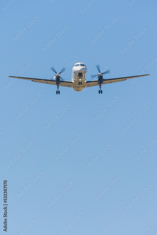 Looking up at an aeroplane with propellers spinning against a blue sky Looking up at an aeroplane with propellers spinning against a blue sky