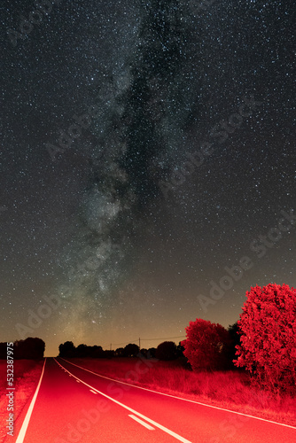Canvas Print Red Road with white lines under the milky way