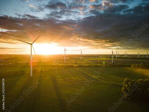 Aerial View of Windturbine against sunset with moody golden lighting photo